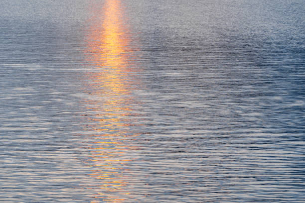 Abstract bokeh background from summer blue sea water at the beach - panoramic banner. Water bokeh backdrop