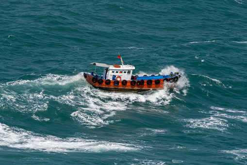 The Asian boat of the pilot in the high sea during a storm.