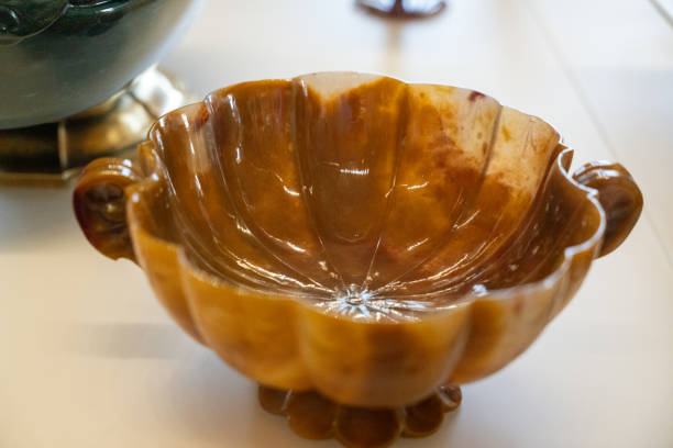 A brown bowl with a gold rim sits on a white table