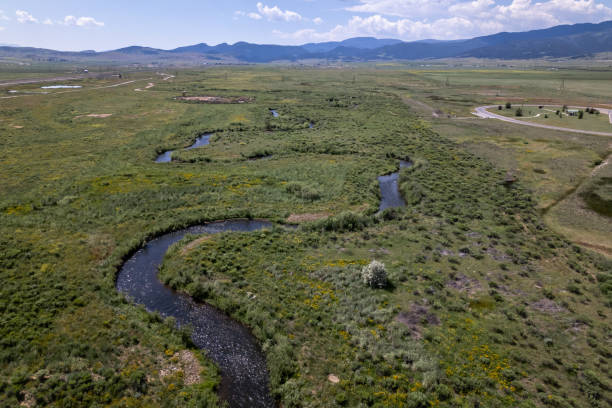 istock Serpentine River Winding Through a Lush Valley with Scenic Mountain Views 2148520033