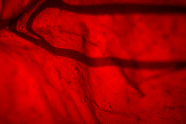 Extreme close up of red empty plastic bag background. The plastic surface is wrinkly and tattered making abstract pattern. Selective focus, shallow depth of field.