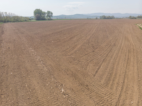 Freshly plowed spring field for planting vegetable seeds. The furrows extend diagonally into the distance.