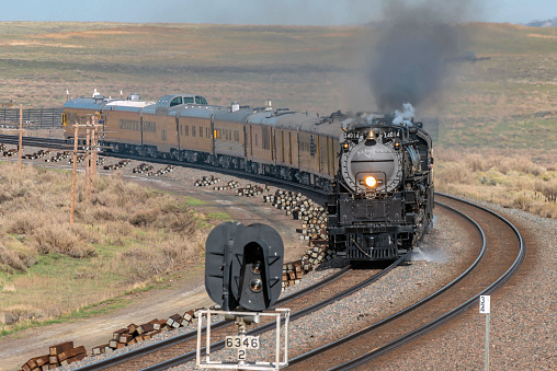 Hanna, WY - May 4, 2019: Union Pacific Great Race 150 train is seen westbound on the Laramie Subdivision near Hanna, Wyoming with the Big Boy 4-8-8-4 4014 leading the Living Legend 4-8-4 844 and SD70ACH 8937 with 9 office cars on the first day of the trip to Ogden, Utah.