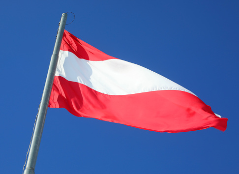 Large Austrian flag with red and white stripes waving