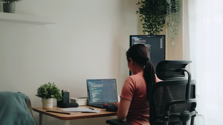 Woman Programmer Engaged in Coding at Desk