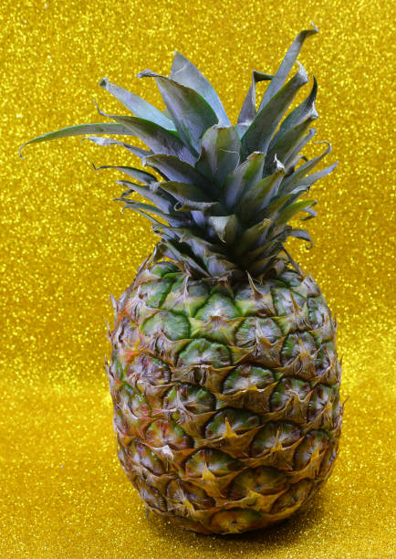 pineapple with golden glitter background as tropical fruit concept