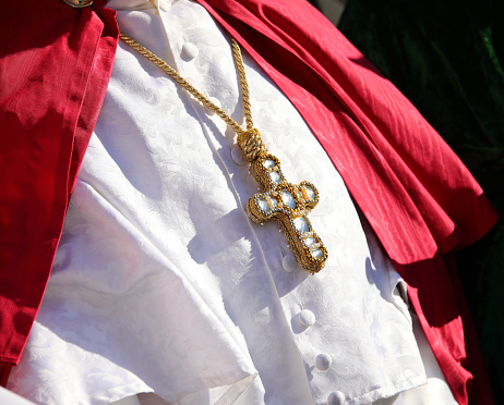 jeweled crucifix necklace worn by a priest during a religious ceremony