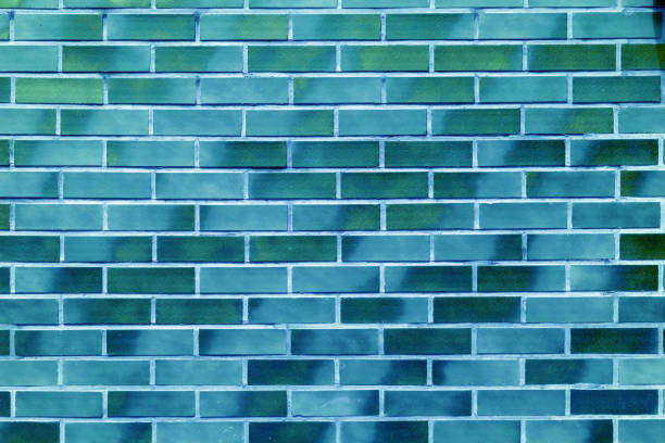 Abstract weathered masonry, aged texture. Stained old stucco green painted  brick wall background, grungy rusty blocks of brickwork close up. Wallpaper, backdrop