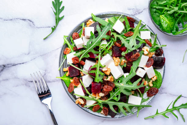 istock Beetroot and white cheese salad with arugula, lettuce, chard and walnuts, white table, copy space. Fresh useful vegetarian dish for healthy eating 2148527772