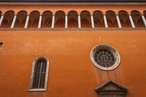 Old terracotta facade with arcade and windows. Italy. Rome