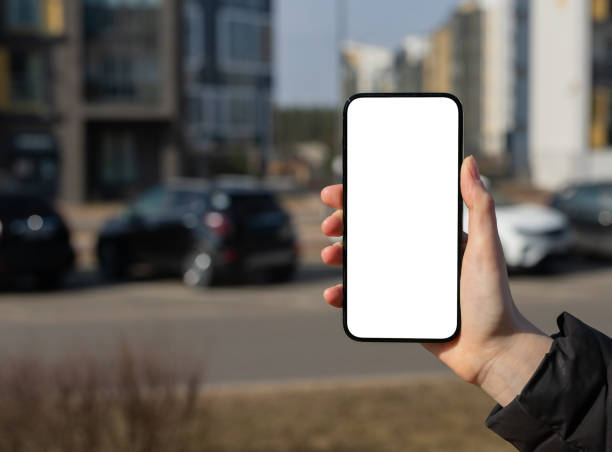 istock Holding mobile phone screen mockup, empty blank smartphone display, blurred city background 2148528252