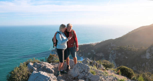 istock Mature couple hike along mountain ridge 2148529233