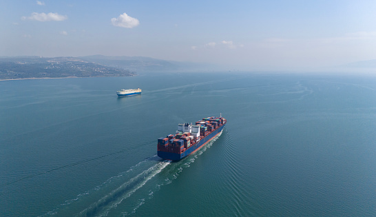 Aerial view of cargo container ship in transit in Izmi Gulf. Aerial view of freight ship with cargo containers. Container ship is crossed the Bosporus in Istanbul and moving to Izmit Gulf, Turkey.