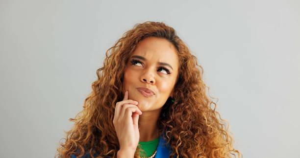 Woman, thinking and idea with decision for choice, selection or pick on a gray studio background. Face of female person in wonder, thought or contemplating offer to choose or opportunity on mockup