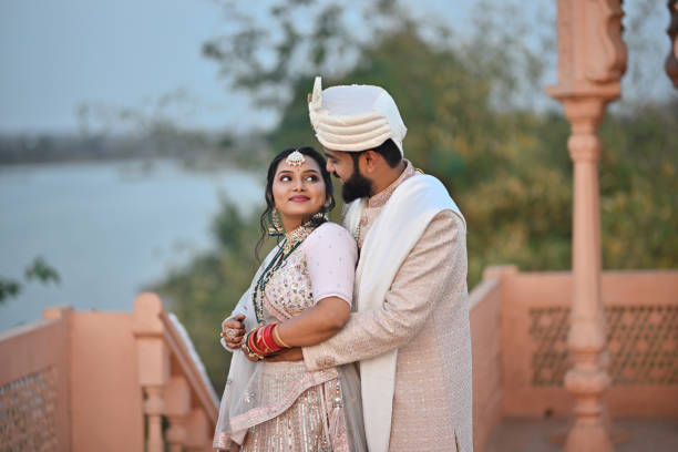 istock Groom lovingly embraces the Bride from behind while they share a glance 2148530730