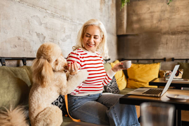 istock Young Woman with Dog Juggles Work and Coffee 2148530910