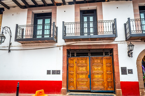 Valle de Bravo, State of Mexico, Mexico January 28 2024 Puerta rustica de madera en edificio blanco con rojo, arquitectura en valle de bravo estado de México
