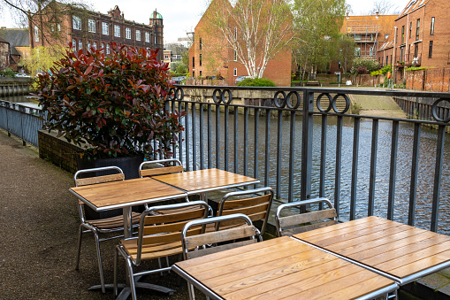 Norwich, Norfolk, UK  April 07 2024. Outdoor tables and chairs beside the River Wensum