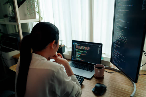istock A tech professional is deeply immersed in writing code on a dual-monitor setup in a minimalist home office, reflecting a blend of focus and creativity. 2148532462