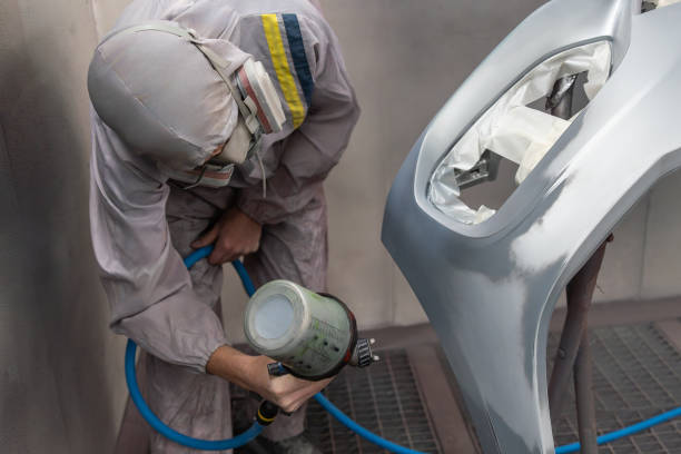istock Painter Applying Paint to Car Bumper in Workshop 2148534625