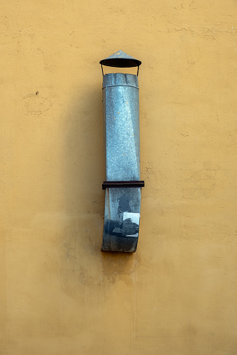 Old ventilation pipe on the wall of a building