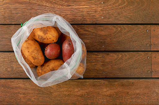 Various varieties of potatoes in fabric packaging. Healthy natural products in an eco bag to boost immunity, healthy lifestyle concept, zero waste. Banner for the store. No plastic. Selective focus