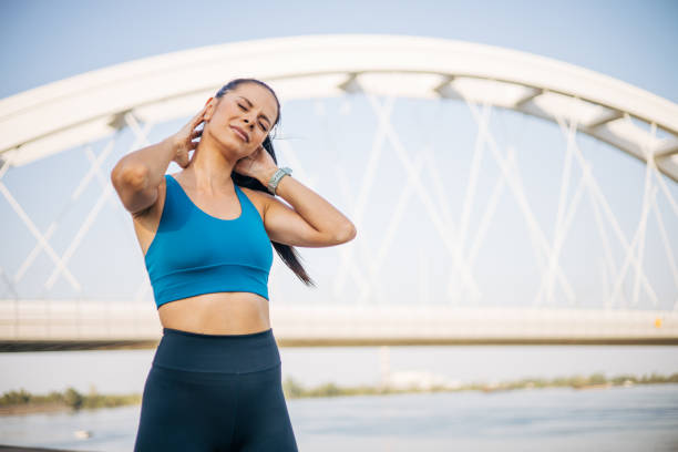 istock Young female jogger feeling pain in her neck 2148539255
