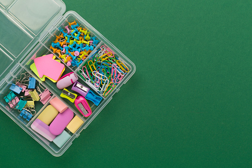 Colorful stationery in organizer on color background, top view