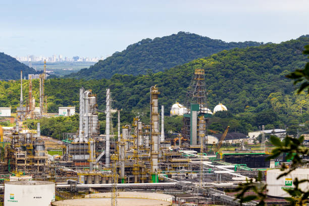 Complex Industrial Refinery in Cubatão with Urban Skyline and Forest. Cubatao, Brazil - March 3, 2024: Complex Industrial Refinery in Cubatão with Urban Skyline and Forest cubatão stock pictures, royalty-free photos & images