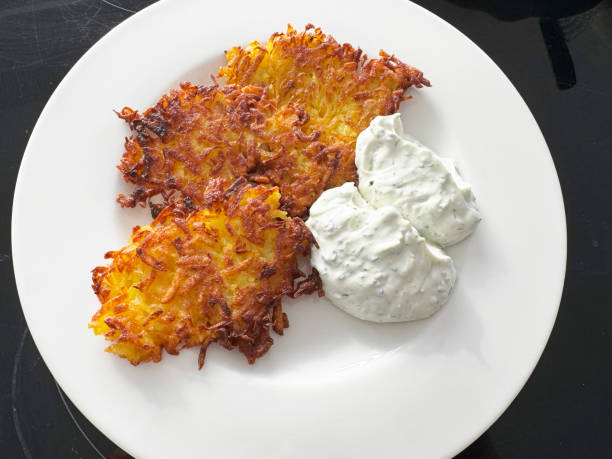 crispy hash browns oval-shaped on a plate on white background