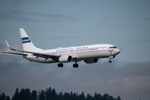 A United Airlines Boeing 737 aircraft, with a retro Continental Airlines livery, about to land at the Spokane International Airport in 2019. United Airlines and Continental Airlines merged in October 2010, becoming United Continental Holdings, and operating under the United Airlines name.