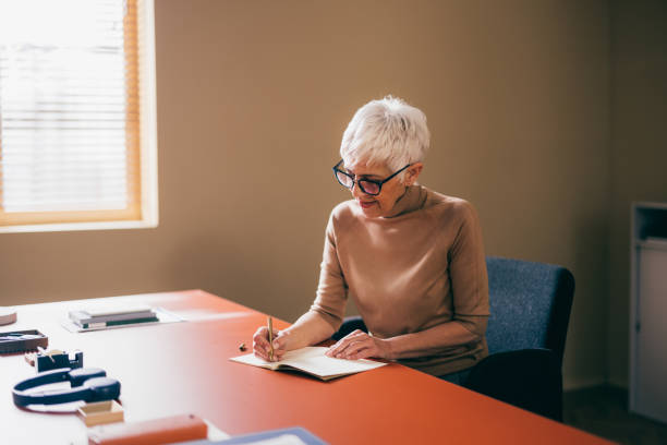 istock Senior Businesswoman Writing Notes in Office 2148542716