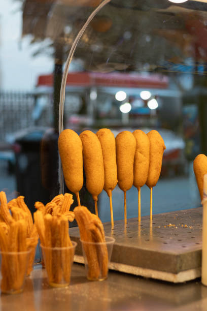 Mexican snack stand at a fair food market, where a small business sells banderillas and churros to its customers Vertical photograph of a Mexican snack stand at a fair food market, where a small business sells banderillas and churros to its customers in a plaza where tourists gather banderilla stock pictures, royalty-free photos & images