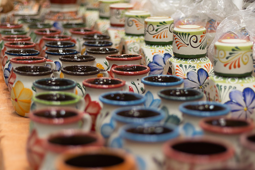 Photograph of a background made of traditional Mexican ceramic cups made in a rustic workshop for a small business store of handmade crafts for tourist souvenirs