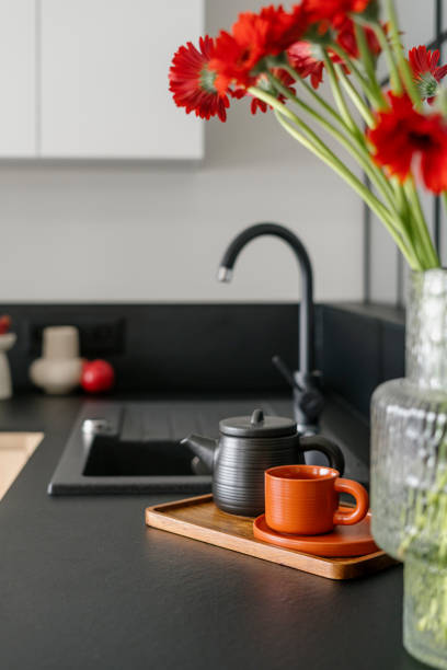 istock Selective focus on wooden tray with teapot and cup on black countertop in kitchen 2148543246
