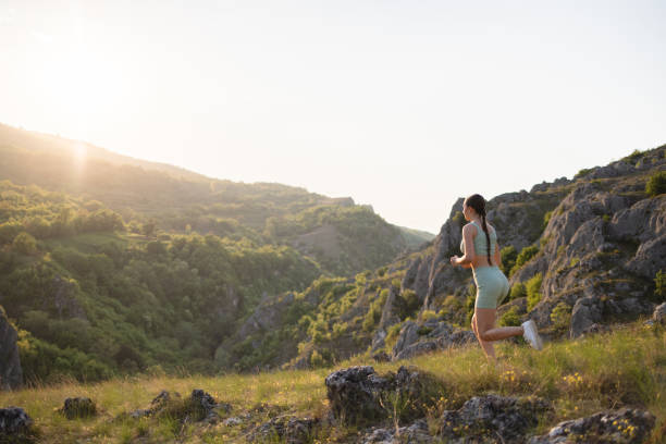 istock Active young Caucasian female athlete running down the mountain, during sunset 2148543384