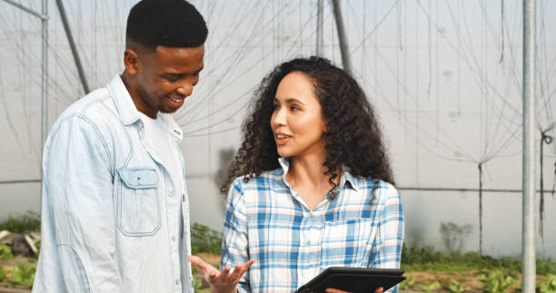istock Conversation, sustainable and couple with tablet in greenhouse for development, growth or farming. Discussion, agriculture and agro people work on digital technology for checklist in environment. 2148543594