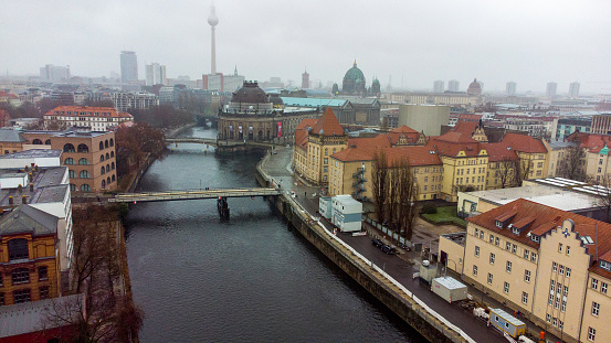 Awe Drone view on Ebertsbrucke and Monbijou bridge over Spree river and  Bode-Museum in foggy Berlin. Berliner Fernsehturm and Berlin Cathedral in distance and blurry in the fog
