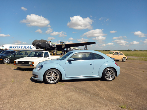 Morón, Argentina - Apr 7, 2024: Blue sport 2010s Volkswagen New Beetle two door sedan at a classic car show in an airfield. Copy space