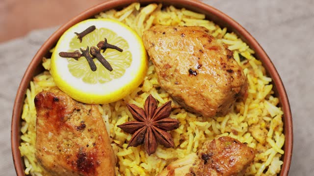 Chicken Biryani with Spices and Lemon in Clay Bowl, Popular Indian and Pakistani Food, Tilt Up Camera Movement