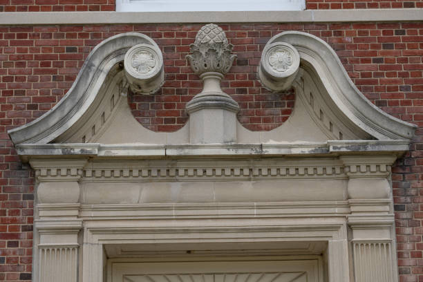 istock Example of crumbling, deteriorating ornamental precast concrete elements, features, on an old brick school building. 2148547805