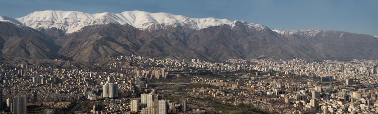 The cityscape of Tehran the capital city of Iran with snow capped mountains behind