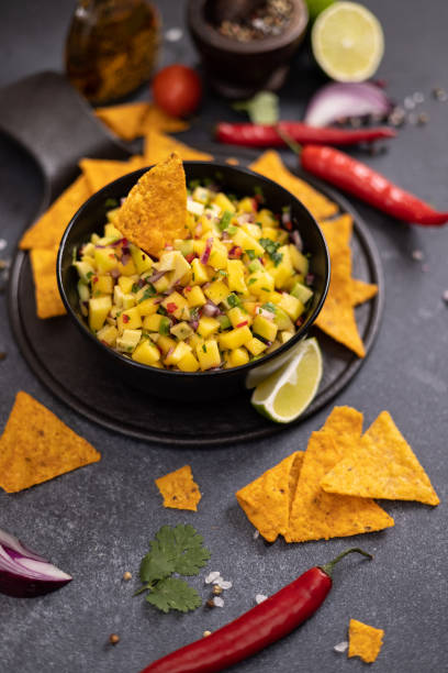istock Freshly made mango salsa in a black ceramic bowl and nacho chips 2148548735