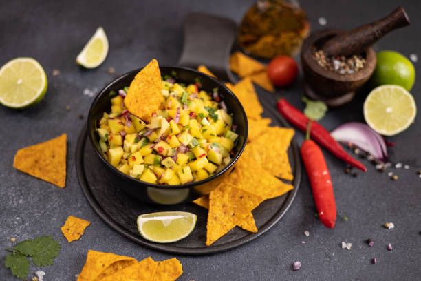 istock Freshly made mango salsa in a black ceramic bowl and nacho chips 2148548741