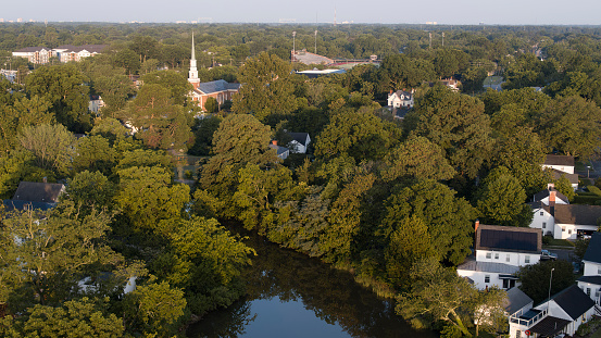 Early morning covers tree lined Residential Neighborhood of Hampton, VA aerial view. Detached houses and road lead to city center on Salters Creek