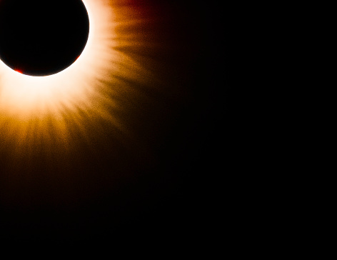 Burnt orange flower-like edge of the sun's Corona with red prominence on the surface of the sun visible during the Total Solar Eclipse 2024, Indiana