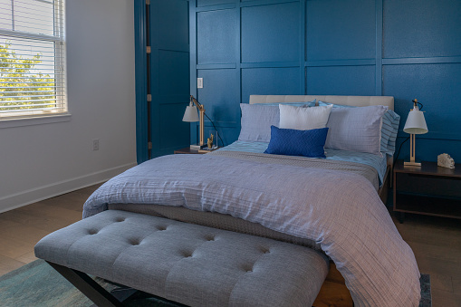 Cozy and Hygge gray, blue bedroom with bench, upholstered headboard, night stands