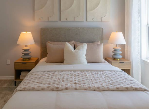 istock Beige tone guest bedroom with upholstered headboard next to window 2148551188