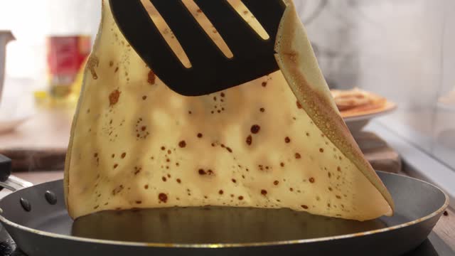 Spatula lifting a pancake, revealing underside texture.