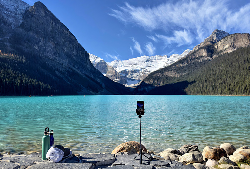 An iPhone on a foreground tripod photographs Canada's spectacular Lake Louise behind it